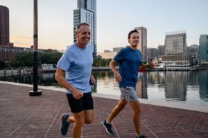 Charlie Engle and a friend running along the Baltimore Inner Harbor waterfront