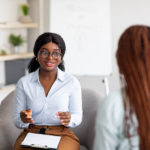 Psychotherapy consultation. Counselor talking to black woman on meeting at office, giving advice to young client. Friendly African American psychologist having session with female customer