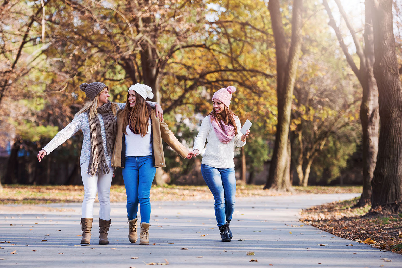 Group of smiling college girls walking in the park - friendship