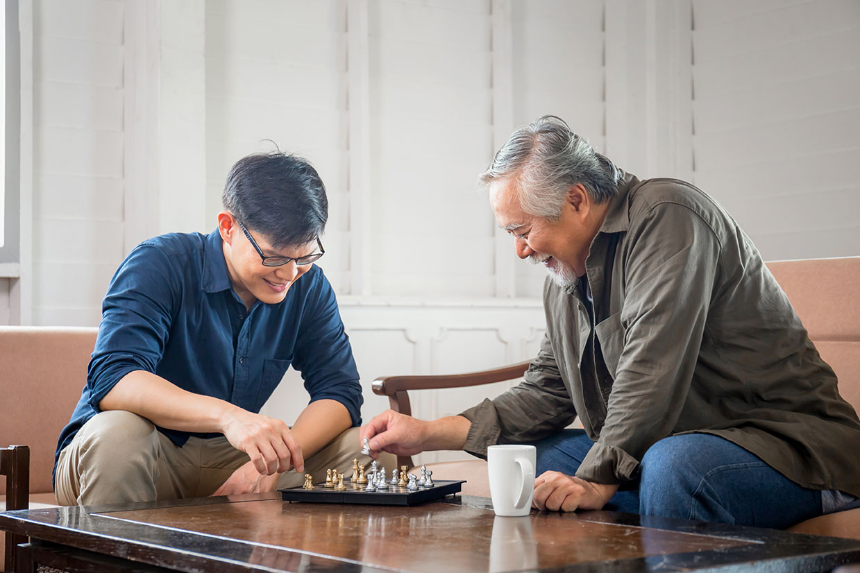 Senior asian father and middle aged son playing chess game in living room, Happiness Asian family concepts